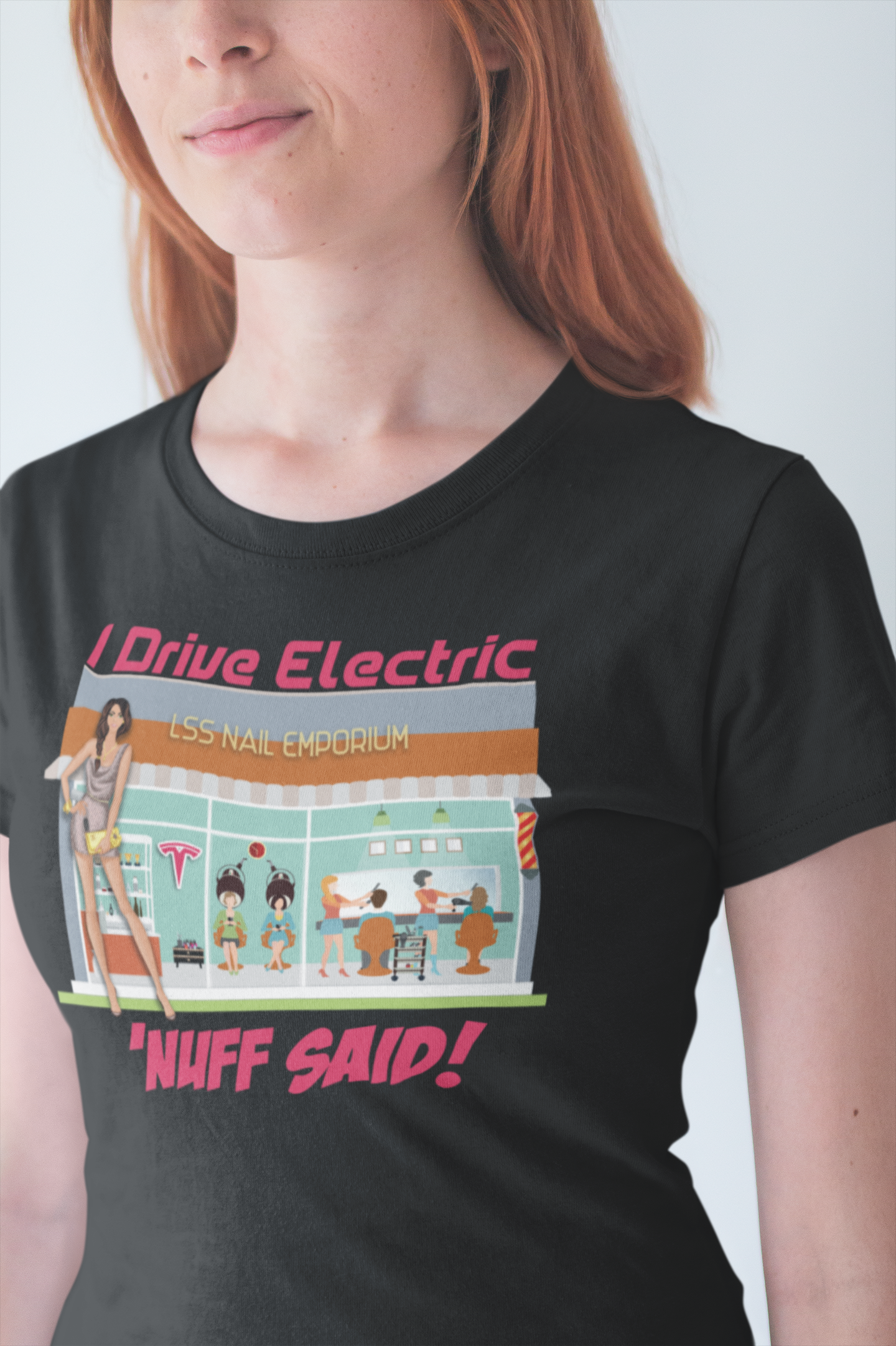 Woman wearing a black t-shirt that has a Salon-scene graphic design and says "I Drive Electric 'NUFF SAID!"