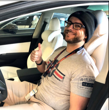 Man sitting inside a Tesla with the white EV Premium Tesla headrests installed