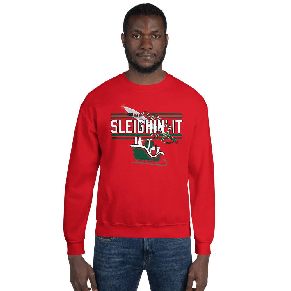 Man wearing a red Christmas-themed sweatshirt with the text "SLEIGHIN' IT" on it