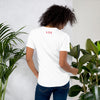 Rear view of a woman wearing a white t-shirt with the letters 