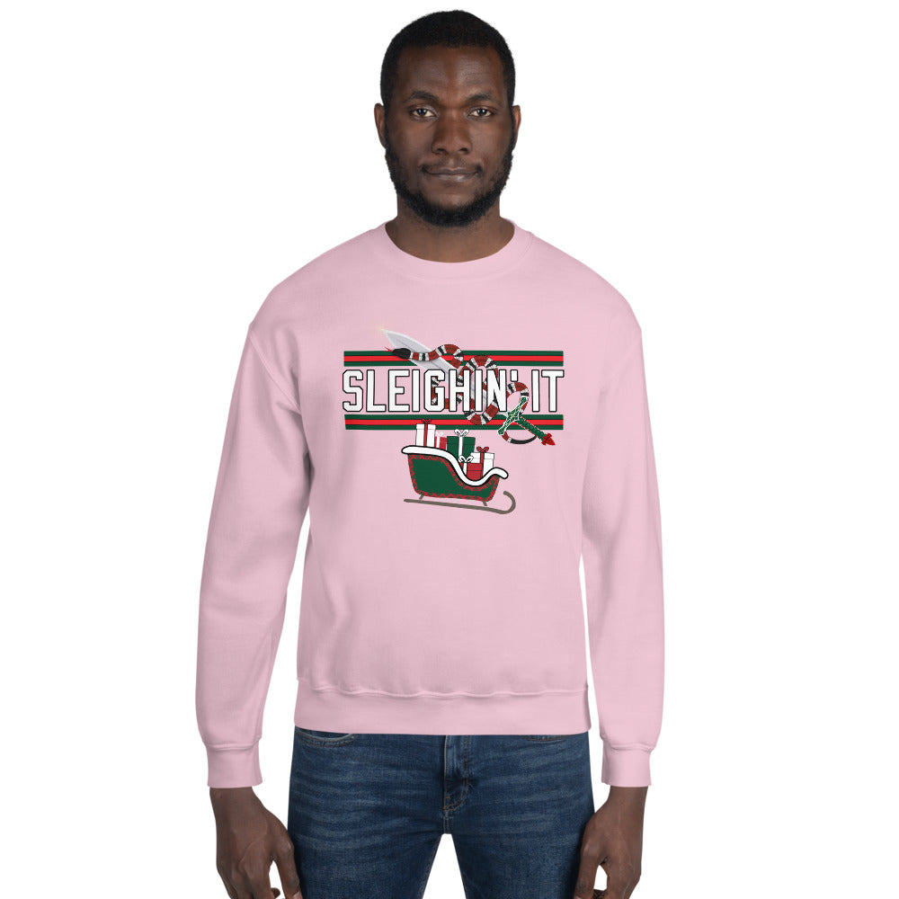 Man wearing a pink Christmas-themed sweatshirt with the text "SLEIGHIN' IT" on it